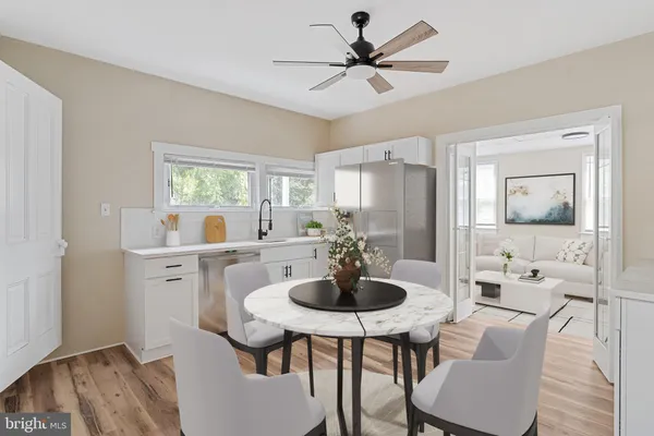 a kitchen with stainless steel appliances a dining table and chairs