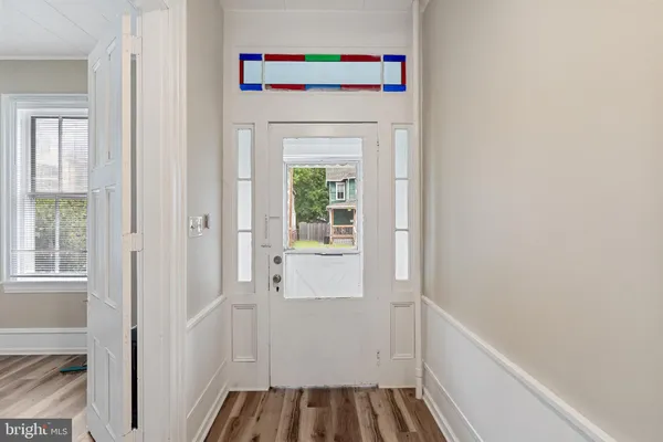 a hallway with a white cabinet door and front door