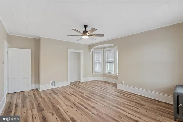 a view of a room with wooden floor and ceiling fan