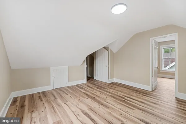 a view of a big room with wooden floor and windows