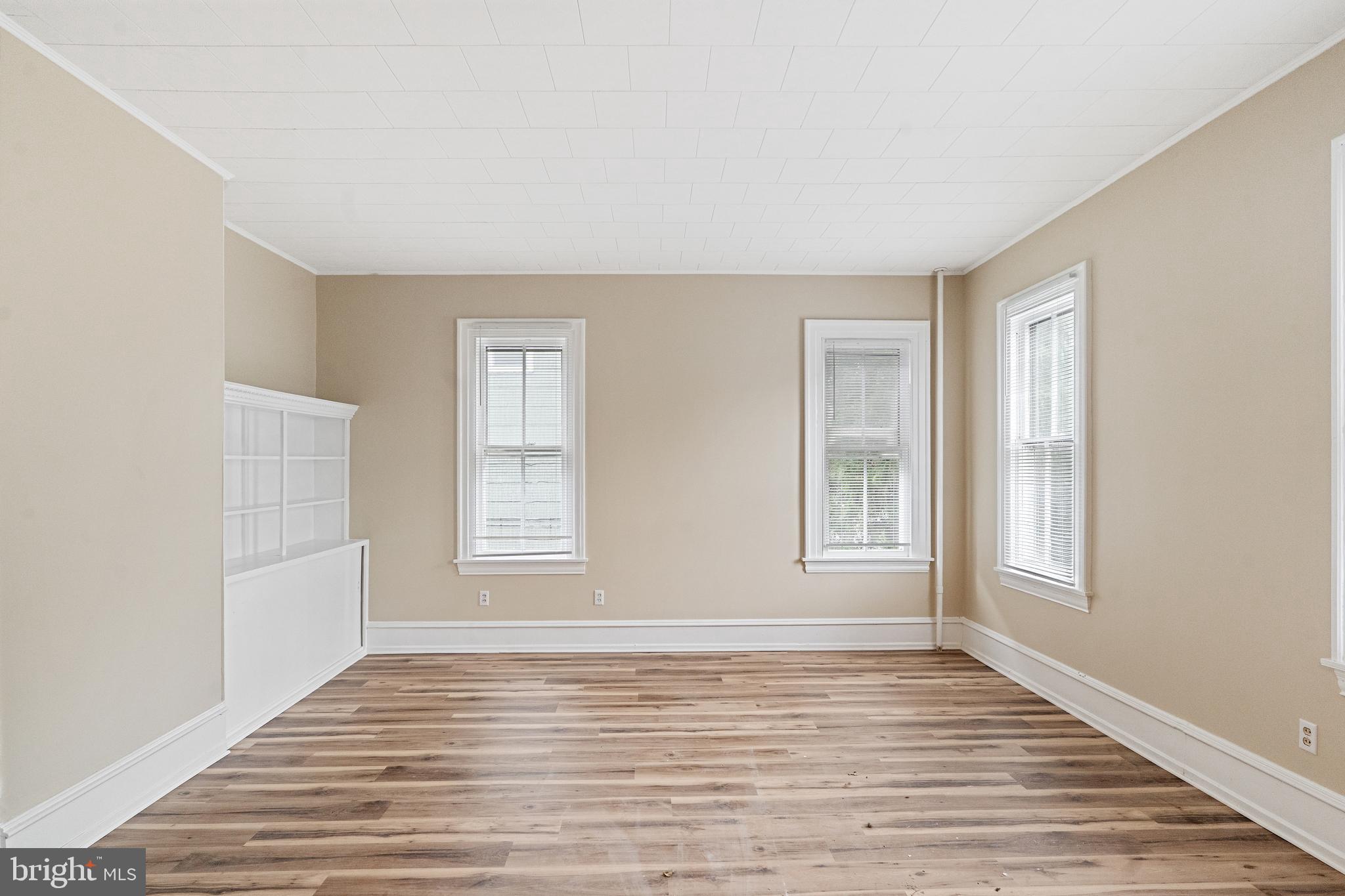 154 7th Street Salem, NJ 08079 - Photo 4 of 48 a view of an empty room with wooden floor and a window