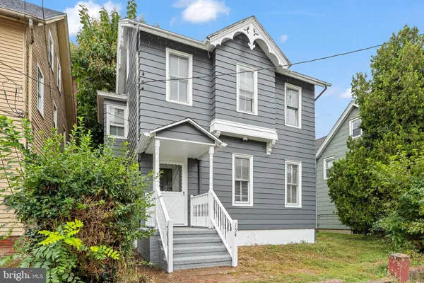 a view of a house with a yard and potted plants