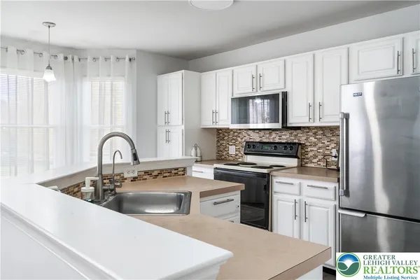a kitchen with stainless steel appliances granite countertop a refrigerator sink and cabinets