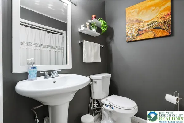 a bathroom with a toilet a sink and a mirror