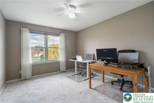 a view of a workspace with furniture and a window