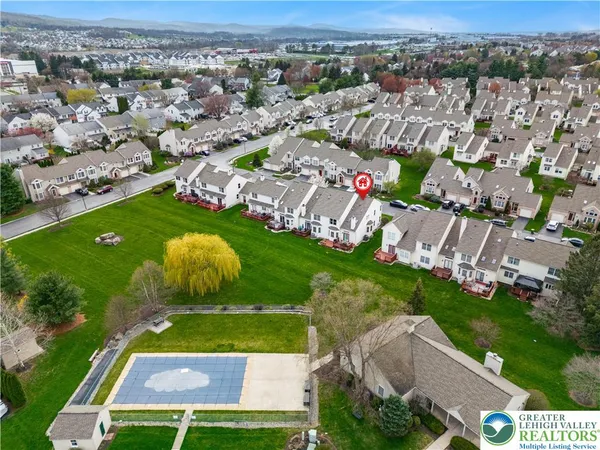 an aerial view of a residential houses with outdoor space and trees
