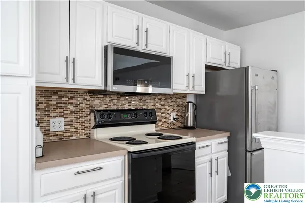 a kitchen with stainless steel appliances a stove a refrigerator a sink and cabinets