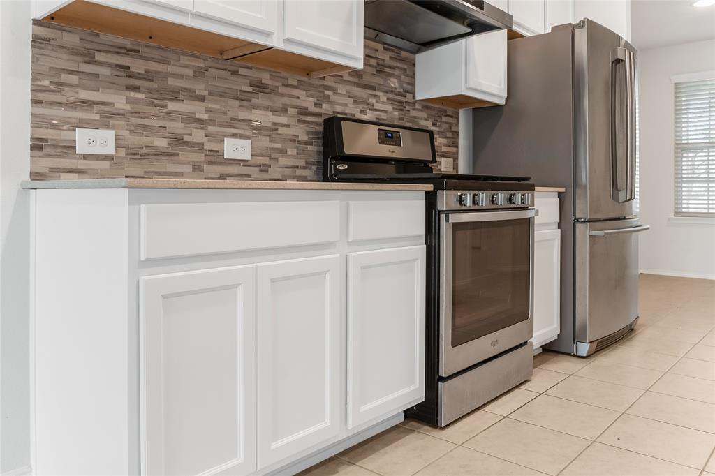 7793 Gulf Walk Road Frisco, TX 75036 - Photo 12 of 37 a kitchen with stainless steel appliances a refrigerator a stove and cabinets