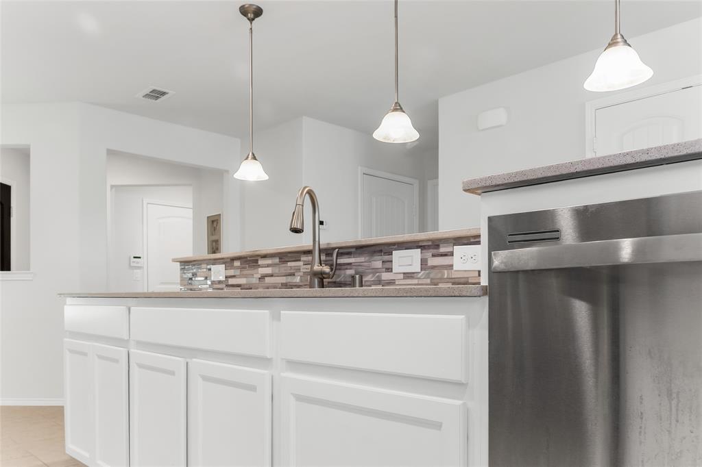 7793 Gulf Walk Road Frisco, TX 75036 - Photo 14 of 37 a kitchen with stainless steel appliances granite countertop white cabinets and a chandelier
