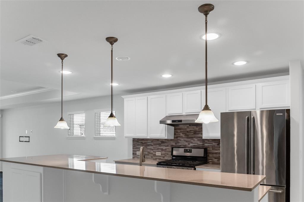 7793 Gulf Walk Road Frisco, TX 75036 - Photo 17 of 37 a kitchen with stainless steel appliances granite countertop a refrigerator a sink and a stove