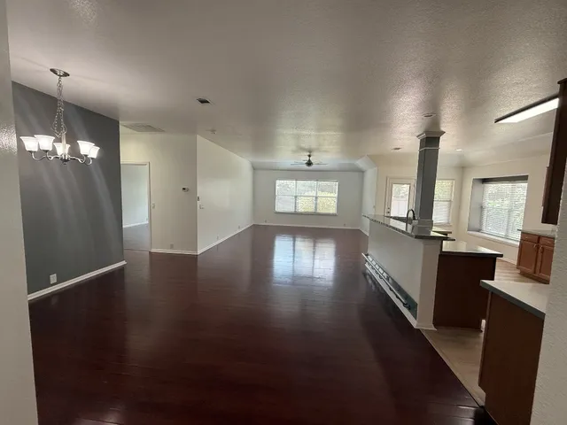 a living room with stainless steel appliances kitchen island wooden floors and view kitchen