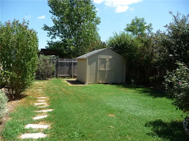 a view of a room with wooden floor chandelier and windows