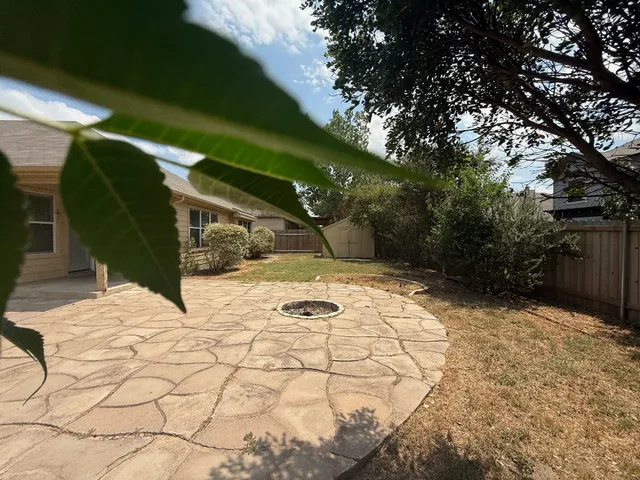 a view of backyard of house with green space