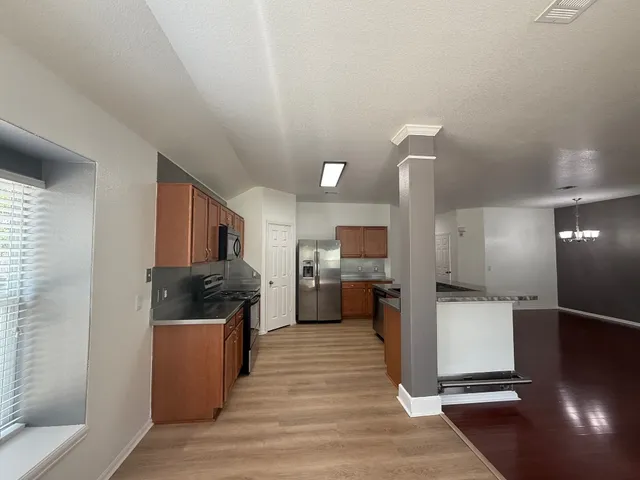a view of a living room and kitchen with wooden floor
