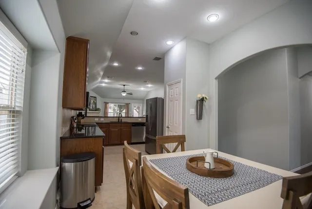 a kitchen with stainless steel appliances granite countertop a refrigerator a stove and a sink with granite countertops