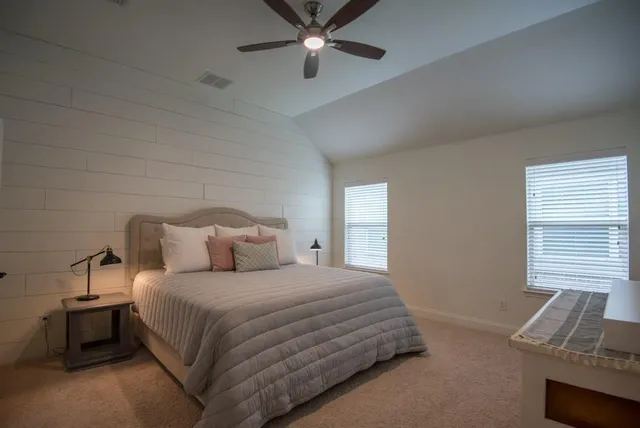a bedroom with a bed and a ceiling fan