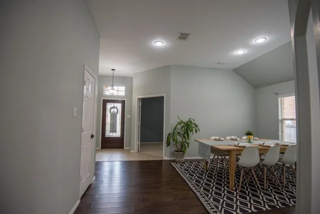 a room with chandelier fan and windows
