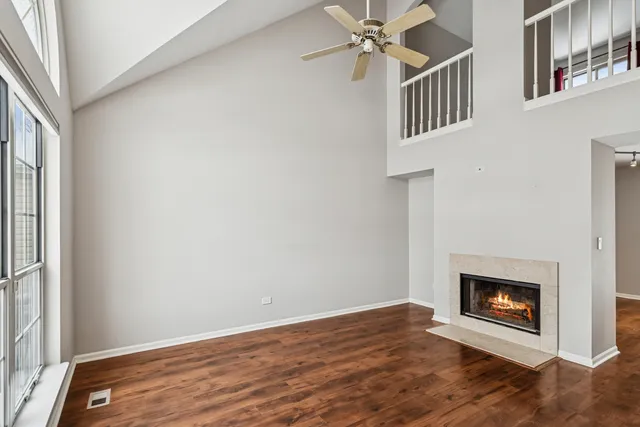 an empty room with windows and fireplace