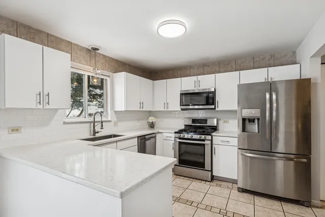 a kitchen with appliances a sink and lots of cabinets