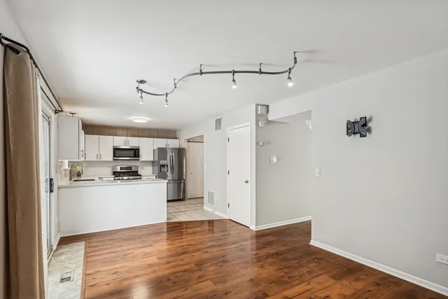 a view of a kitchen with a sink dishwasher a refrigerator and wooden floor