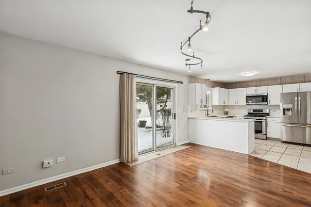 a kitchen with granite countertop white cabinets and stainless steel appliances