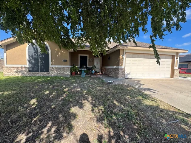 a tree in front of a white house