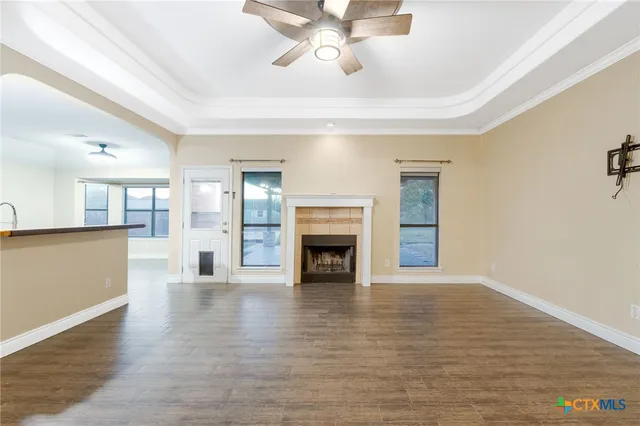 a view of a livingroom with a fireplace a chandelier and wooden floor