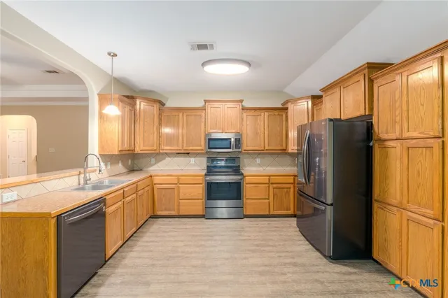 a kitchen with stainless steel appliances granite countertop a refrigerator and a stove