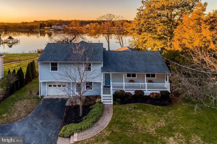 a aerial view of a house with a yard and lake view
