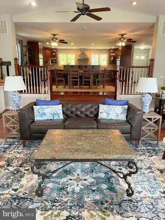 a living room with furniture a chandelier and view of dining room