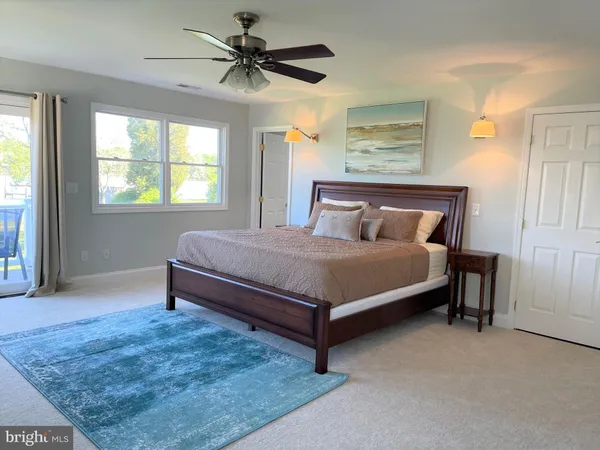a spacious bedroom with a bed and a flat screen tv