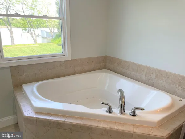 a bathroom with a tub sink and mirror