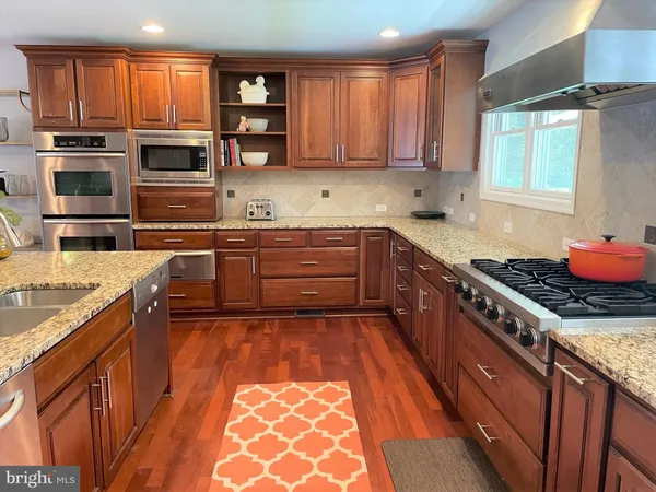 a kitchen with stainless steel appliances granite countertop a stove top oven a sink and dishwasher
