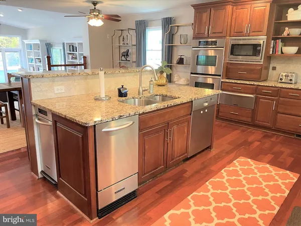 a kitchen with stainless steel appliances granite countertop a sink and a stove