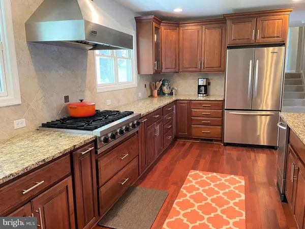 a kitchen with stainless steel appliances granite countertop a refrigerator stove and sink