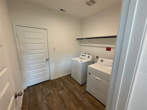 a view of empty room with wooden floor and window