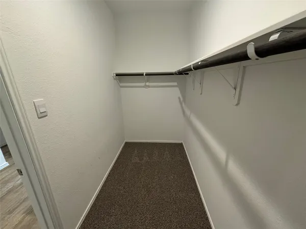 a view of walk in closet with empty racks