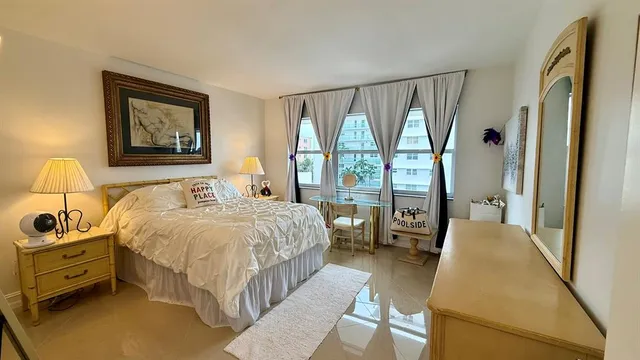 a bedroom with a bed chair and a large window