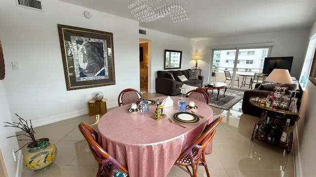 a dining room with furniture a chandelier and window
