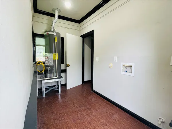 a view of a hallway with wooden floor and furniture
