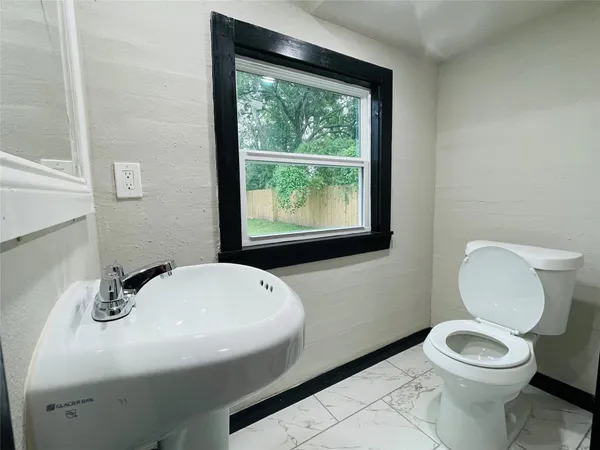 a bathroom with a sink a toilet and a mirror