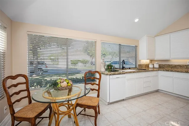a kitchen with granite countertop white cabinets and white appliances