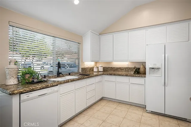 a kitchen with stainless steel appliances granite countertop a sink and a white cabinets