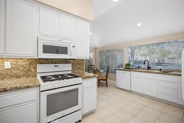 a kitchen with granite countertop cabinets stainless steel appliances and a sink