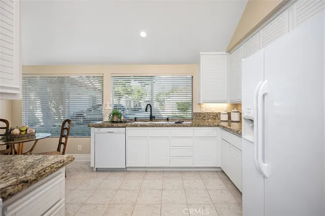 a kitchen with granite countertop a sink and a stove top oven