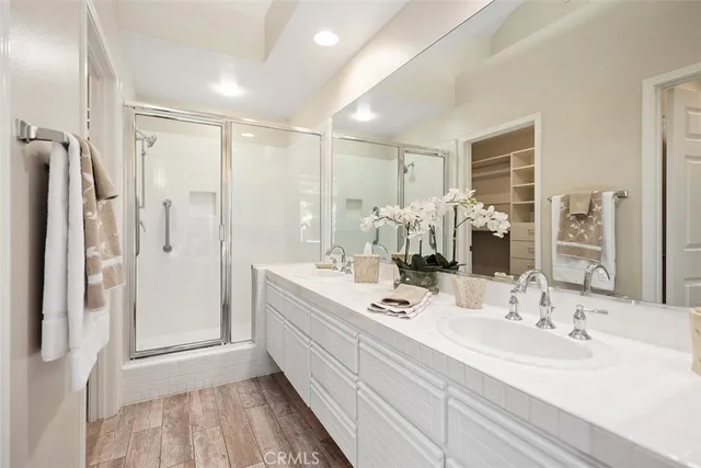 a bathroom with a double vanity sink a mirror a shower and a bathtub