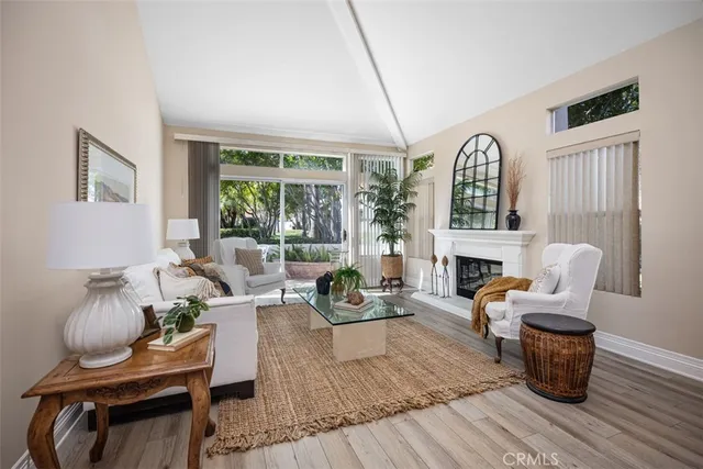 a living room with furniture fireplace and a large window