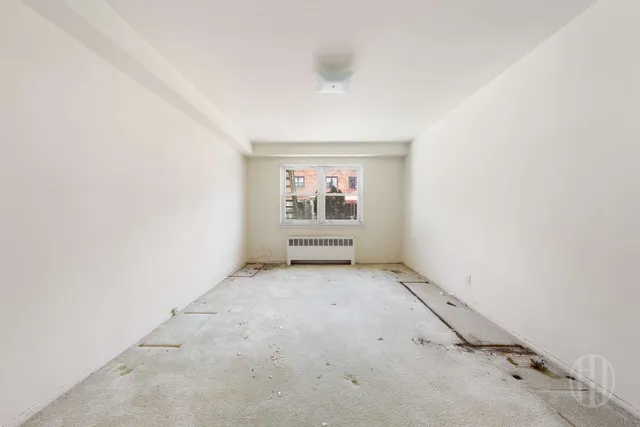 an empty room with white walls and windows