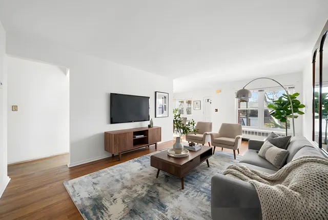 a living room with furniture wooden floor and a flat screen tv