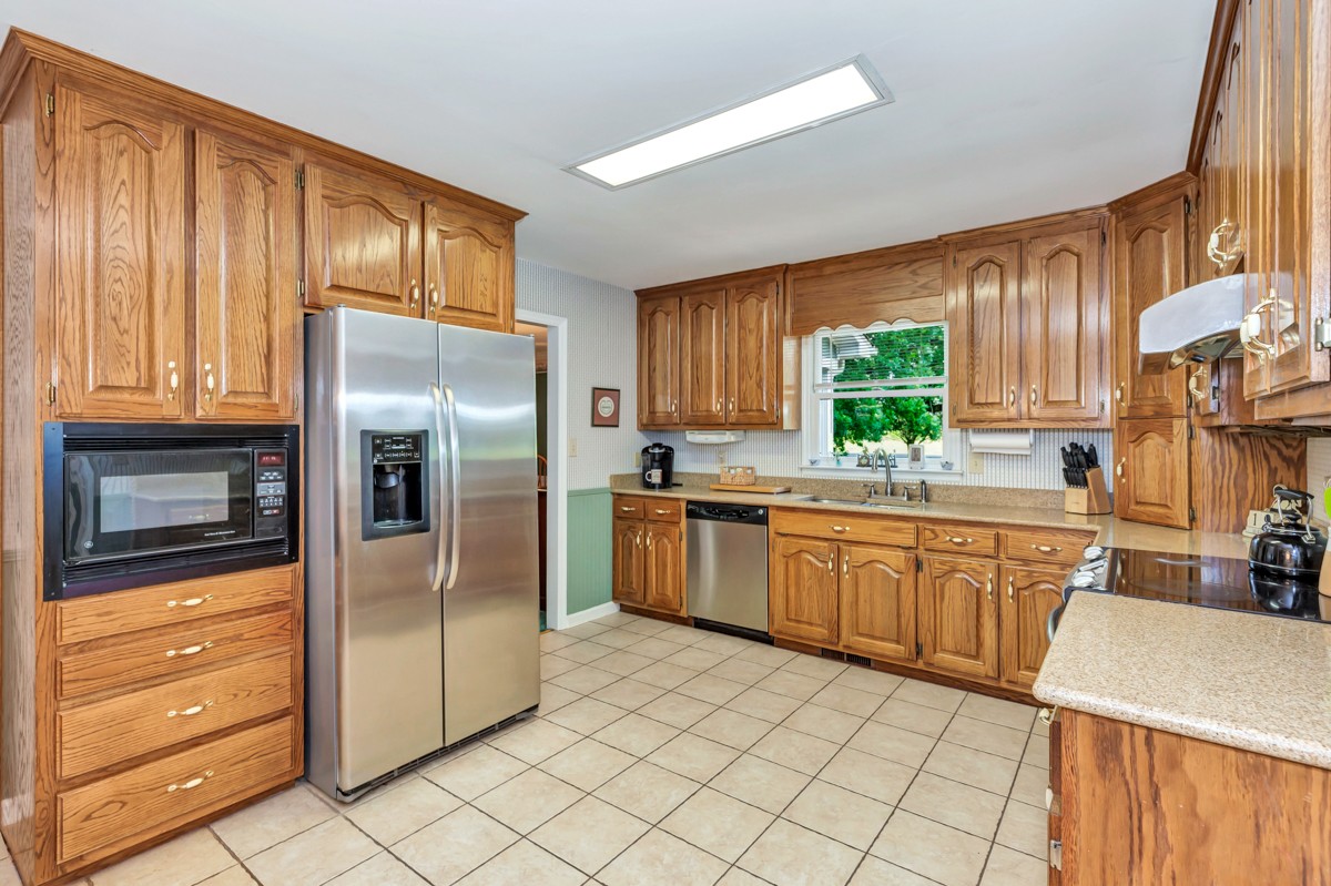 1713 Macedonia Road Ardmore, AL 35739 - Photo 8 of 35 a kitchen with granite countertop a refrigerator stove top oven dining table and chairs
